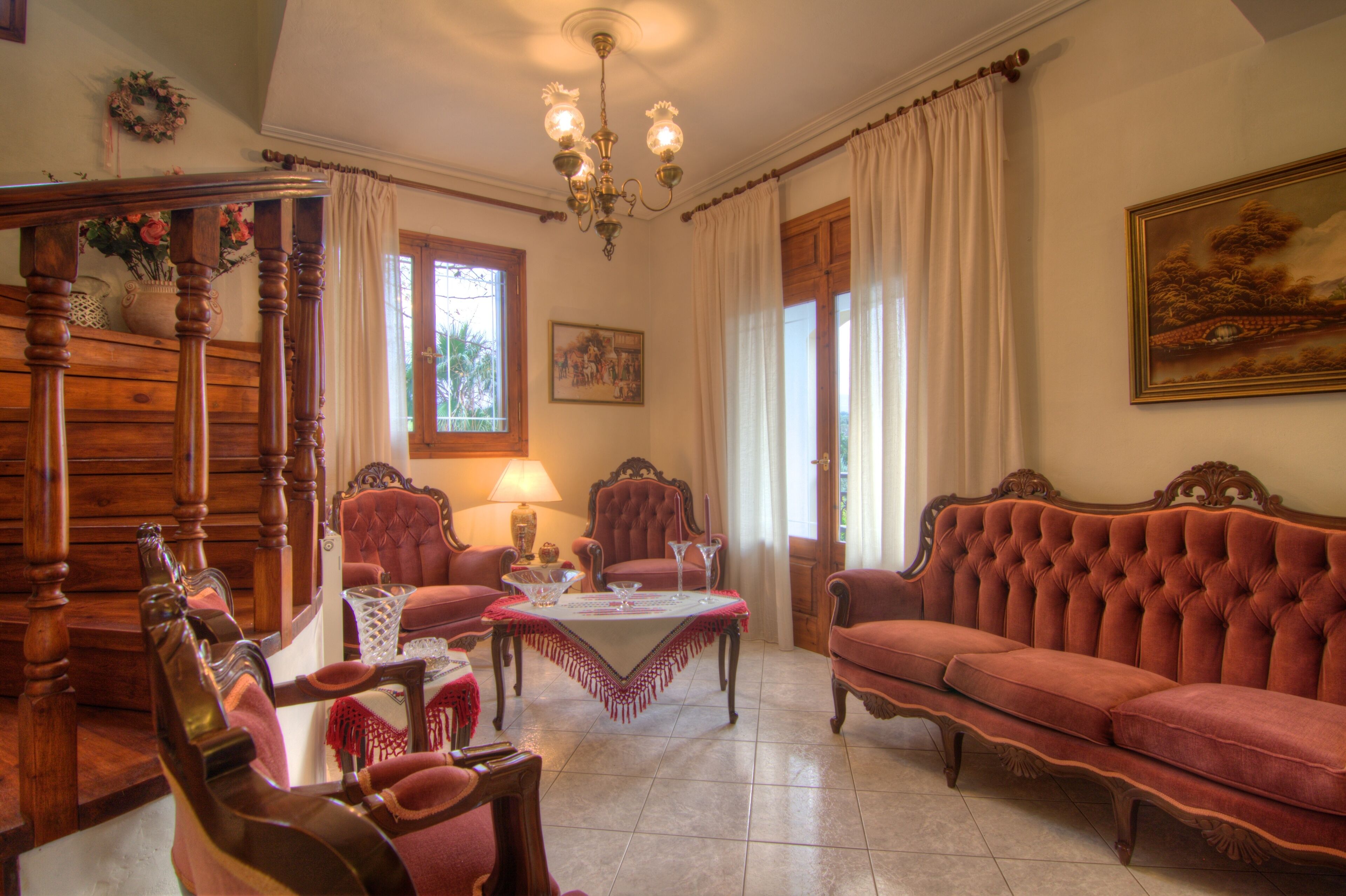 A traditional room with a wooden four-poster bed, a red sofa, and a dining table set for four.