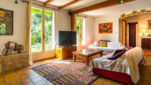 A cozy living room with a television, sofa, and coffee table. - house / villa - 8 rooms - 8/10 persons (Auriol)