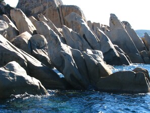 A rocky coastline with large boulders and clear blue water. - PLEASURE STAY BY THE SEA, 300M FROM MANCINU BEACH AND ITS ACTIVITIES (Propriano)