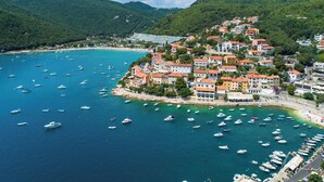 A coastal town with a marina filled with boats, surrounded by lush green hills and colorful buildings. - Modern Villa w / pool, a few minutes from the sea, surrounded by nature (Brgod)