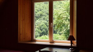 Quarto com uma janela grande, uma mesa e uma cadeira.
