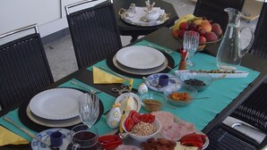 A table set with various food items and utensils, indicating a dining setup. - Vacation house BLACK & WHITE (Bromberg)