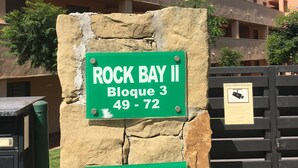 Letrero que indica 'ROCK BAY II Bloque 3 49-72' y 'Número 13' en una pared de piedra.