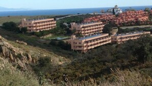 Un área residencial costera con edificios de varios pisos, algunos con balcones, y vista al mar.