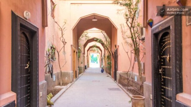 Un passadís amb portals arquejats que condueix a un espai interior lluminós.