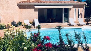 Una casa amb piscina, gandules blanques i zona de terrassa.