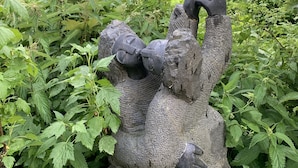 A stone sculpture of a figure in a garden setting. - authentic luxury chalet with garden (La Forclaz)
