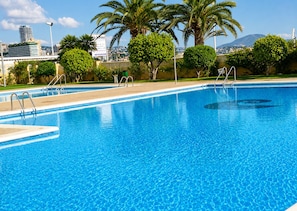Uma piscina azul cristalina com vista para o horizonte urbano.