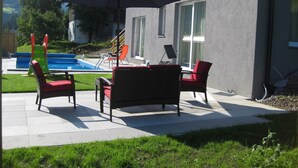 A patio with outdoor furniture, a pool, and a mountain view. - Luxury vacation home for summer with private pool and winter at the slopes (Annaberg)