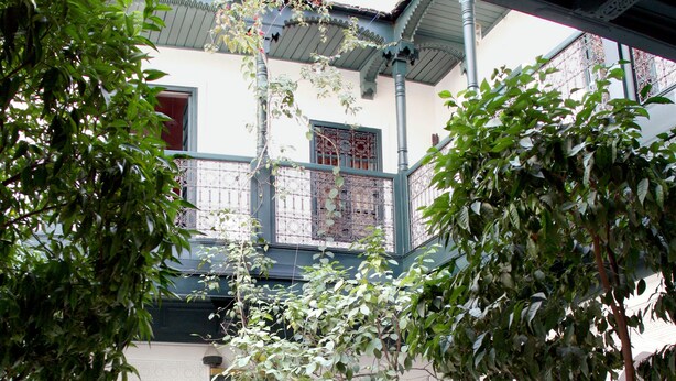 Un patio exterior con zona de estar, una fuente y un árbol.