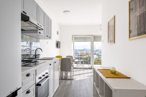 A modern kitchen with a dining area and a balcony with a view of boats. - Apartment with 2 bedrooms, terrace with sea view, right on the beach (Betina)