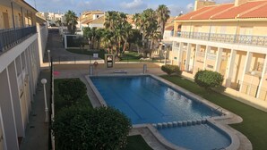 A swimming pool surrounded by greenery and buildings. - Hillside / sea giant pool Alicante-Torrevieja-La Mata (Torrevieja)