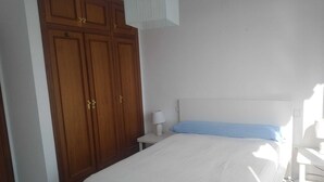 A bedroom with a bed, a nightstand, a lamp, and a wardrobe. - Hillside / sea giant pool Alicante-Torrevieja-La Mata (Torrevieja)