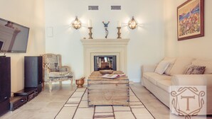 A living room with a fireplace, a television, and a sofa.