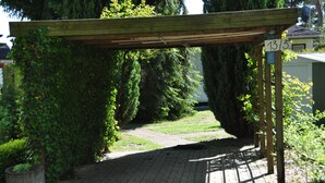 A wooden pergola with a brick pathway leading through a garden area. - Relaxing holiday in the detached house Selma! (Trassenheide)