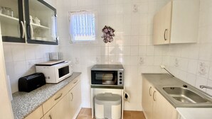 A compact kitchen with a microwave, toaster, and oven. There is a sink and a trash bin. - Relaxing holiday in the detached house Selma! (Trassenheide)