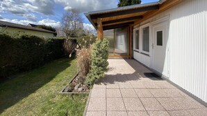 A modern house with a covered patio, a garden, and a clear blue sky. - Relaxing holiday in the detached house Selma! (Trassenheide)