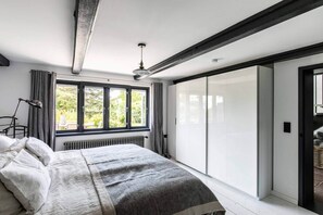 Une chambre à coucher avec un lit, un radiateur, une fenêtre et une porte coulissante.