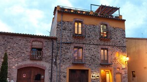 Un edificio de piedra con puertas y ventanas de madera, un balcón y un letrero que dice "El Torno".