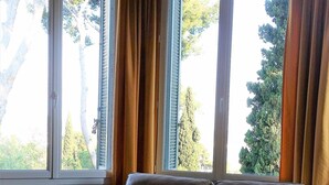 A living room with a sofa, a coffee table with flowers, and large windows with curtains. - House / Villa - SANARY SUR MERHouse with character (Sanary-Sur-Mer)