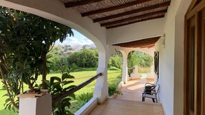 A covered outdoor area with a wooden ceiling, white walls, and a view of a green landscape. - Beautiful 10 people villa with pool on one of the most beautiful places in Albufeira (Albufeira)