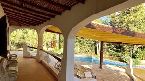 A covered outdoor area with a pool, benches, and a view of the surrounding greenery. - Beautiful 10 people villa with pool on one of the most beautiful places in Albufeira (Albufeira)