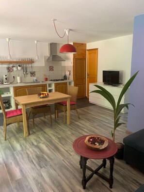 A compact living space with a dining area, kitchen, and seating area.
