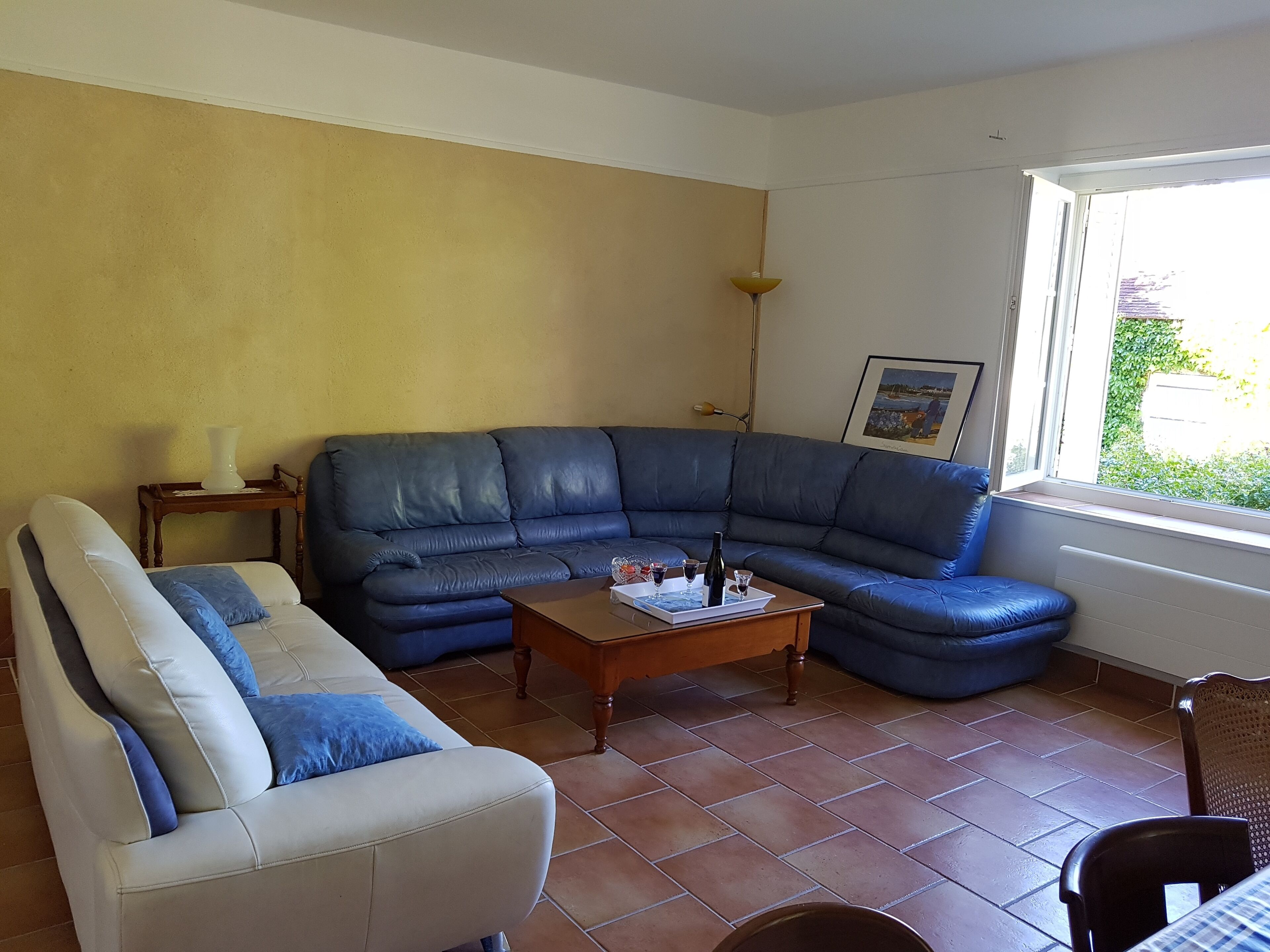A living room with a sofa, a coffee table, and a window.
