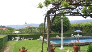 Un jardin avec une piscine, un espace salon extérieur et un lampadaire.