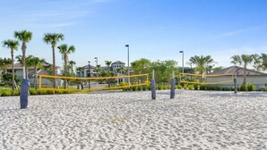 A beach volleyball court with a net, surrounded by sand and palm trees. - Charming Vacation Townhome with Pool CG1576 (Davenport)