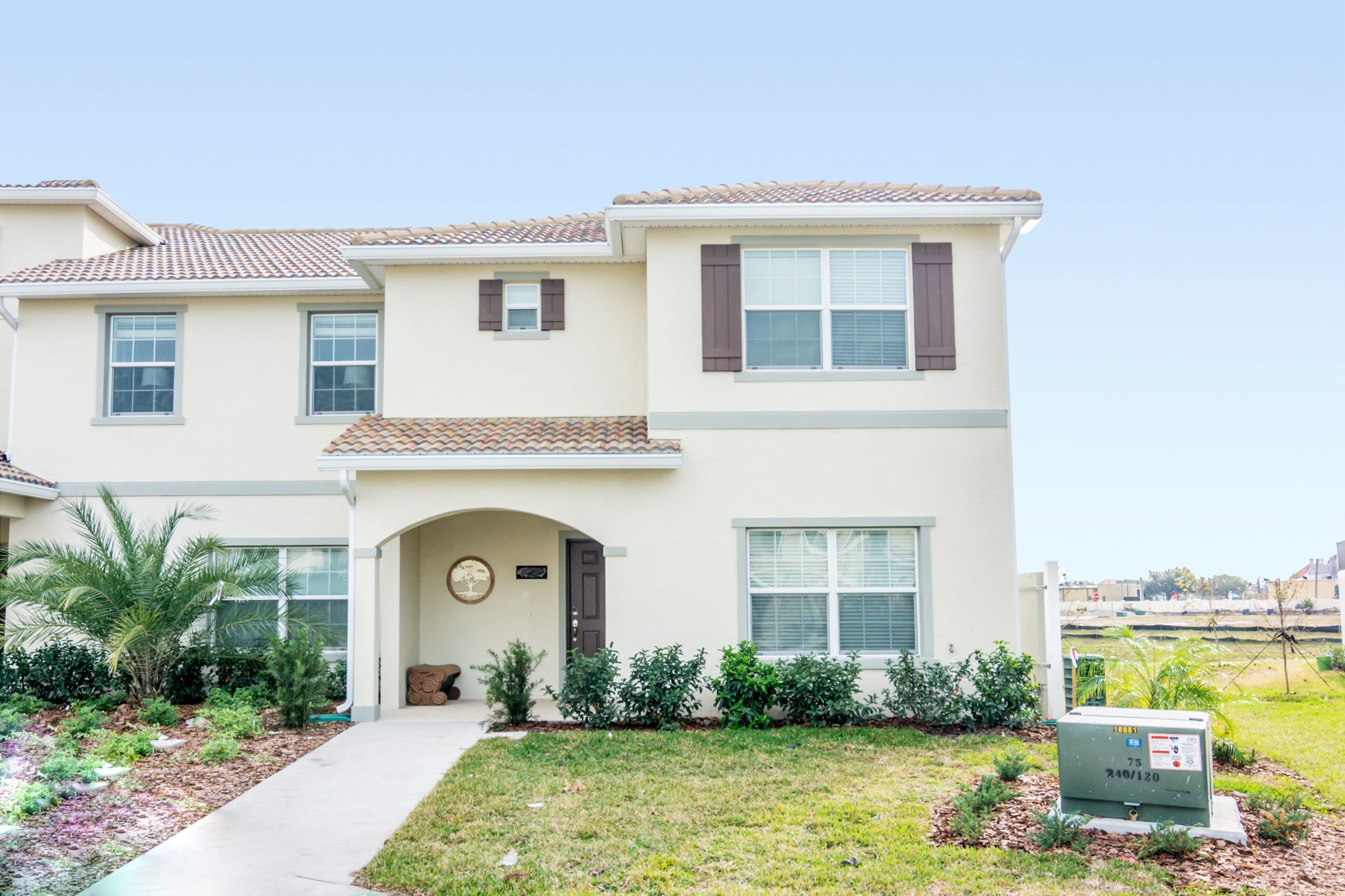 A two-story house with a front entrance, a small porch, and a well-maintained lawn.