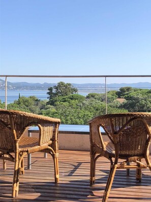 Two wicker chairs on a wooden deck overlooking a body of water and greenery. - Holiday house in Giens with a fantastic view over the bay of Almanarre (Hyères)