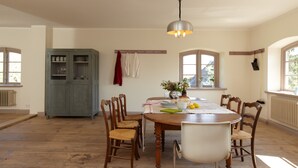 A dining area with a wooden table, chairs, a chandelier, and a cabinet. - Spacious and stylish in the monument to the Müritz, near the lake and golf course (Lexow)