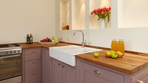 A modern kitchen with a built-in oven, a sink, and a wooden countertop. - Spacious and stylish in the monument to the Müritz, near the lake and golf course (Lexow)
