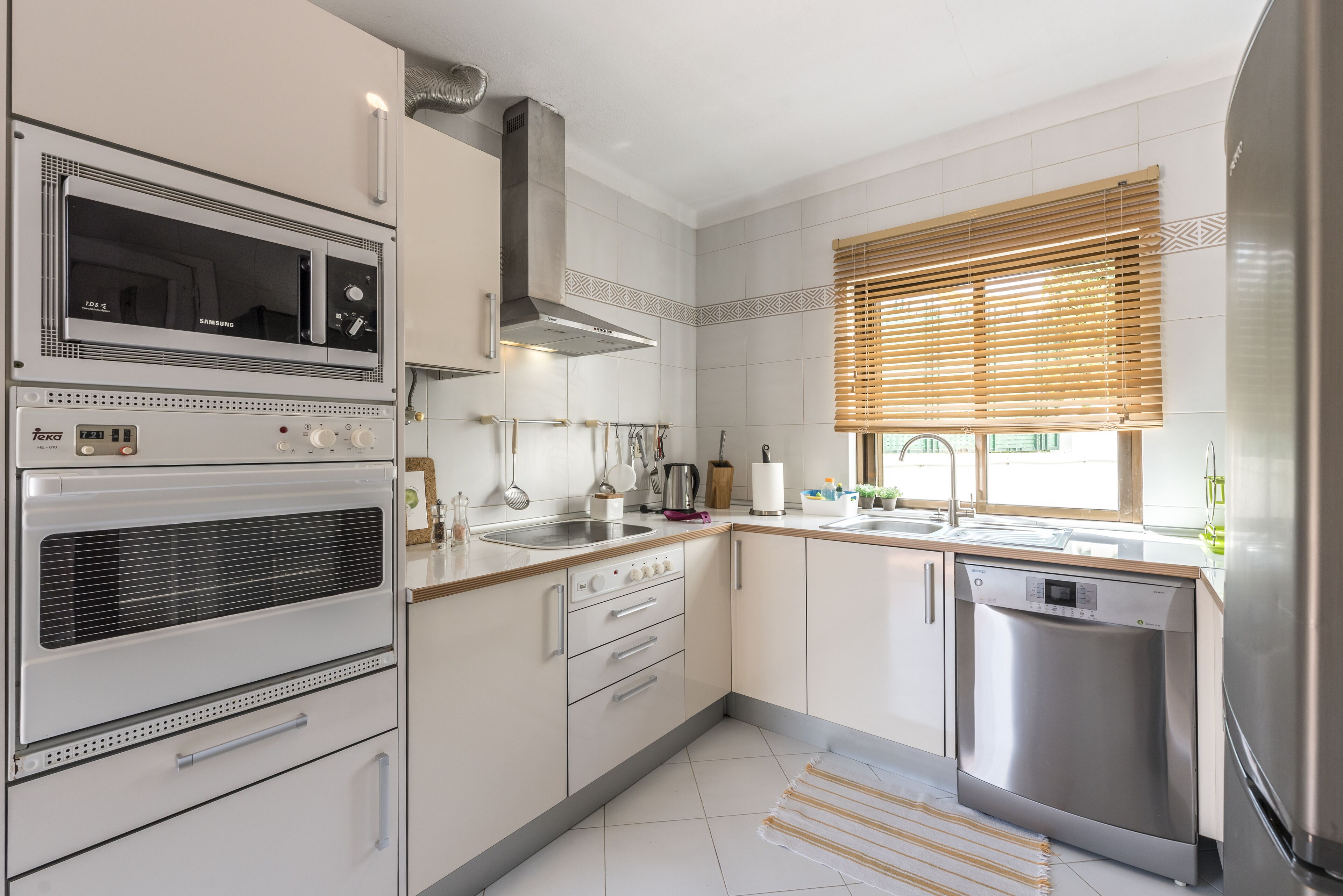 A modern kitchen with stainless steel appliances, a built-in oven, a microwave, and a dishwasher.