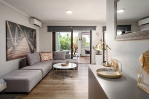 Un salon moderne avec un canapé gris, une table basse ronde et un grand tableau représentant un pont.