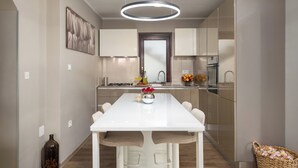 A modern kitchen with a white countertop, a hanging light fixture, and a vase with flowers. - Family-friendly,air-conditioned, quiet location, garden, barbecue, pets welcome. (Porec)