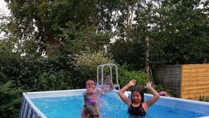 An above-ground swimming pool with a ladder, surrounded by greenery. - Spacious u. child-friendly apartment (Oesterdeichstrich)