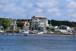 Un port de plaisance où sont amarrés des bateaux, entouré d’immeubles à plusieurs étages dotés de balcons.