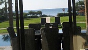 Een kamer met uitzicht op een golfbaan en de oceaan.