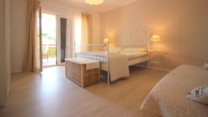 Een slaapkamer met een bed, nachtkastje, lamp en uitzicht op het landschap.