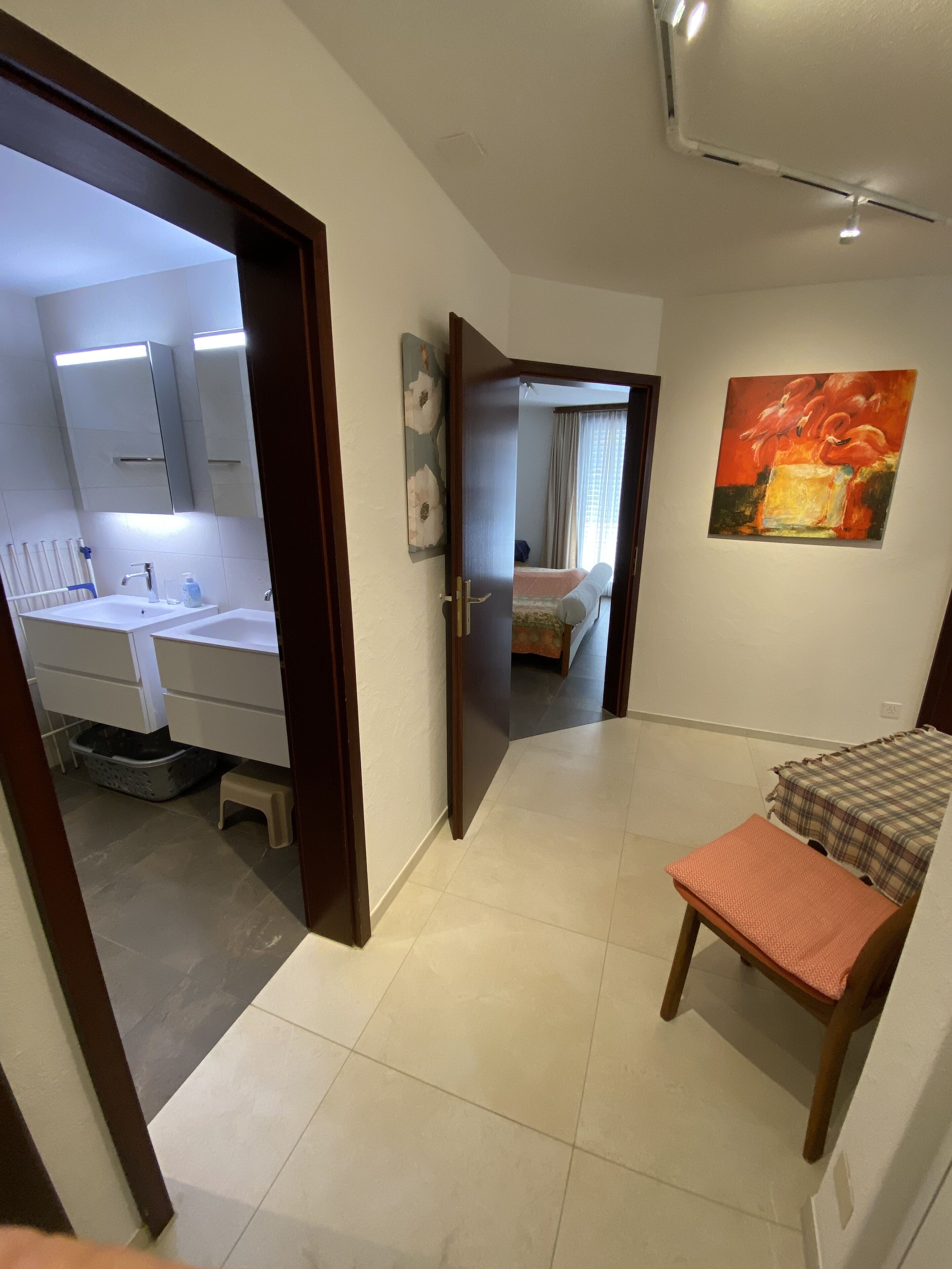 Ein Hotelzimmer mit Bad, einem Bett, einem kleinen Tisch und einem Gemälde an der Wand.