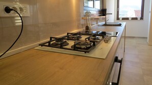 A modern kitchen with a gas stove, a window with a view, and a countertop. - Modern apartment near the beach for 4 people (Trogir)