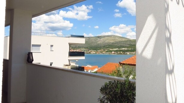 A balcony with a view of a coastal town, a mountain, and a body of water. - Modern apartment near the beach for 4 people (Trogir)
