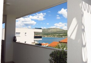 A balcony with a view of a coastal town, a mountain, and a body of water. - Modern apartment near the beach for 4 people (Trogir)