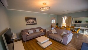 A modern living room with two sofas, a coffee table, and a dining area with chairs and a table. - Luxury villa Vitam in Imotski, private pool (Zmijavci)