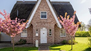 A brick house with a triangular roof and a white door.