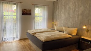 Un dormitorio con una cama grande, dos mesitas de noche y una lámpara de pared.