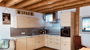 A modern kitchen with wooden cabinets, a built-in oven, and a coffee maker. - Holiday tower Niederstetten (Niederstetten)