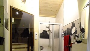 Un baño con ducha, lavamanos e inodoro.